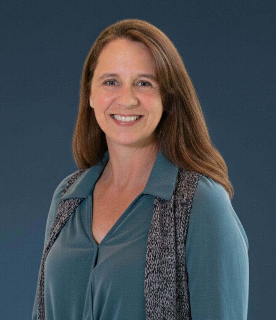 Professional woman smiling in a teal outfit, showcased by Ceek Next Innovations.